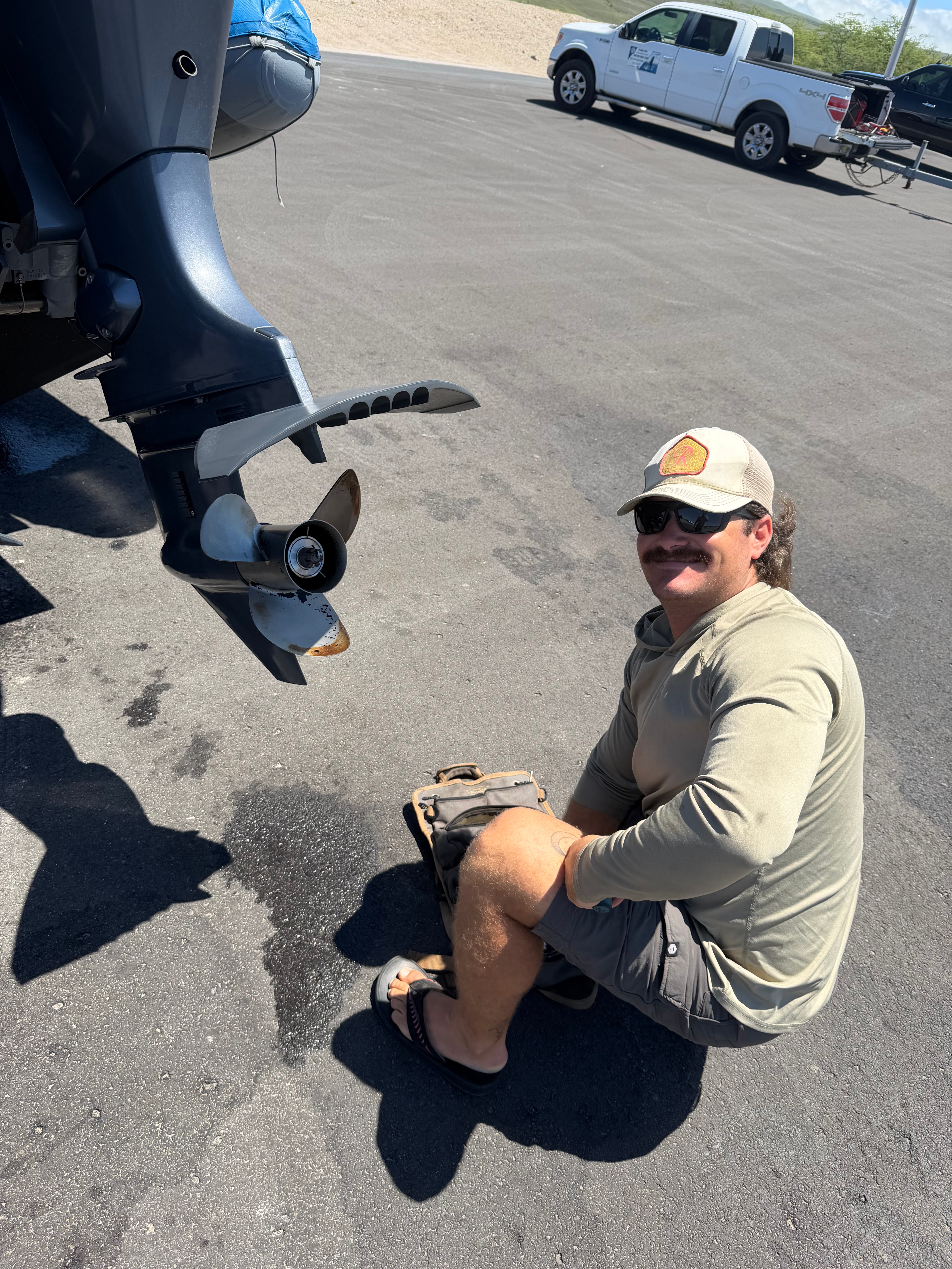 Cole working on a yamaha outboard service in Kawaihae Harbor